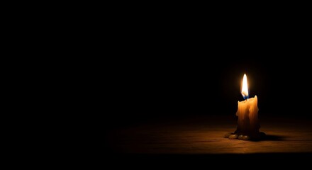Fototapeta premium Candle Burning Brightly in Dark Room with Wooden Surface