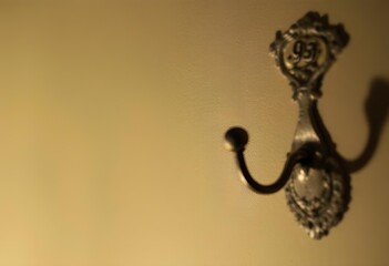 Ornate Double Hook on Cream Wall, Vintage Style