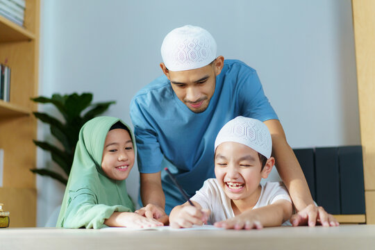 Asian muslim family, a man teaching children a school homework