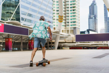 Elderly man in Hawaiian shirt skateboarding in city. Active senior lifestyle and leisure.