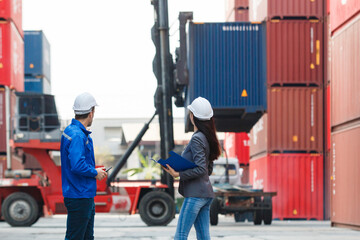Businesswoman talking with container yard officer about import export logistics, global trade, and...