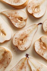Overhead shot of pear halves arranged in a creamy liquid, dusted with cinnamon.  The pears are light yellow-brown and appear ripe and juicy