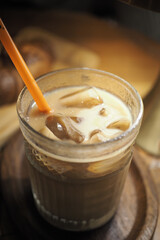 Iced beverage with straw served in glass cup