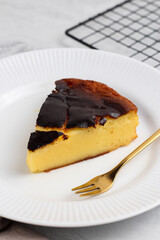 Burned cheese cake on a white plate.