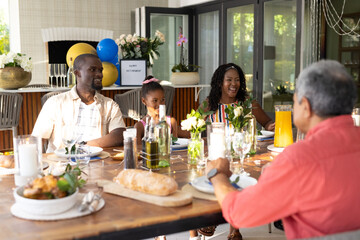 Family celebrating birthday at home, enjoying meal and sharing laughter together