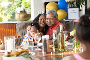 Hugging grandfather, granddaughter at family gathering, celebrating joyfully together
