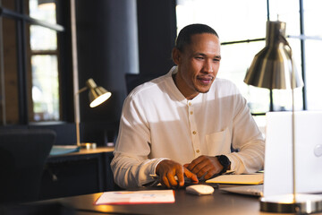 Businessman in office working on laptop, focused on late-night project