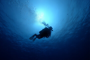 Fototapeta premium Silhouette of Scuba Diver Exploring Deep Blue Ocean