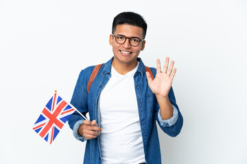 Young Ecuadorian woman holding an United Kingdom flag isolated on white background saluting with hand with happy expression