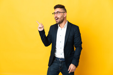 Businessman over isolated yellow background intending to realizes the solution while lifting a...