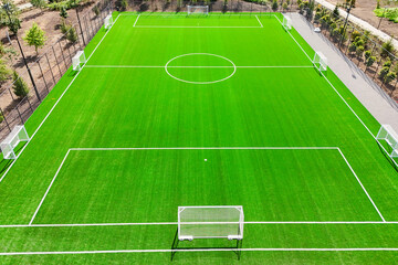Fototapeta premium A soccer field with a white goal and white lines. The field is green and well maintained. Concept of sportsmanship and teamwork