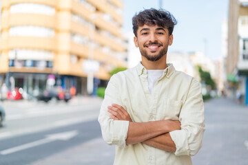Young Arabian handsome man at outdoors keeping the arms crossed in frontal position