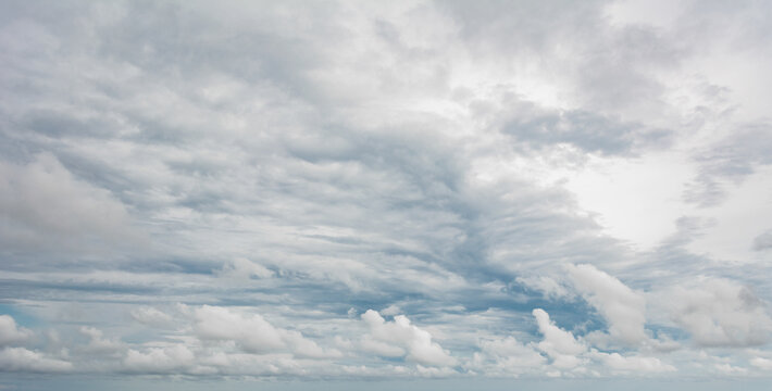 Dark clouds filling the sky with a break of light shining through creating a dramatic and atmospheric weather scene - Powered by Adobe