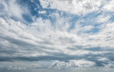 White clouds scattered around a vivid blue sky forming a circular opening that creates a dynamic and atmospheric scene