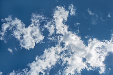 White clouds scattered around a vivid blue sky forming a circular opening that creates a dynamic and atmospheric scene