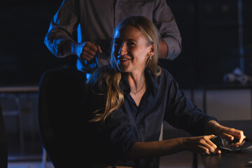 Businesswoman smiling while working late at office, engaging in conversation