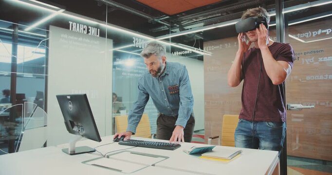 NEW YORK - April 5, 2017:Two likable men in research center testing improved version of virtual reality glasses. Young student looking left and right, down and up.