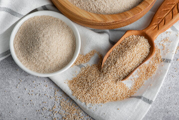 Raw organic amaranth grain and amaranth flour. Amaranth seeds in a wooden bowl on a table.
