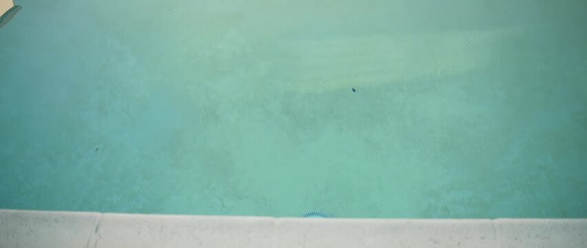 Smooth camera transition from poolside edge to wide view of courtyard