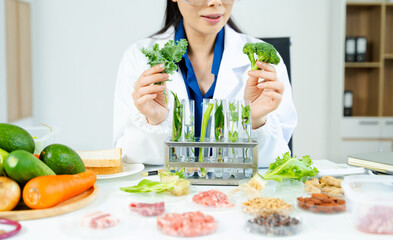 Nutritionist in safety goggles analyzing kale and vegetables in a food science lab. Health, diet, research, and clean eating concept. Clinical setting