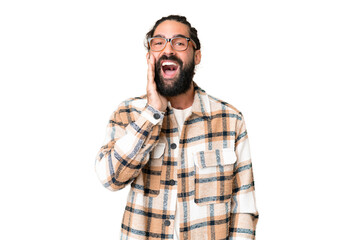 Young man with beard over isolated chroma key background shouting with mouth wide open