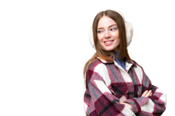 Young pretty woman wearing winter muffs over isolated chroma key background with arms crossed and happy