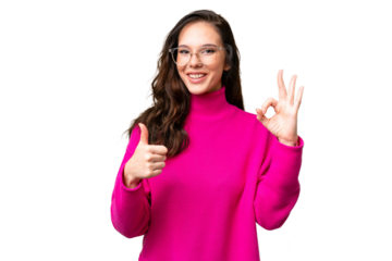 Young caucasian woman isolated over isolated background showing ok sign and thumb up gesture