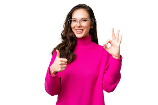 Young caucasian woman isolated over isolated background showing ok sign and thumb up gesture