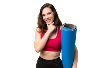 Young sport woman going to yoga classes while holding a mat over isolated background happy and smiling