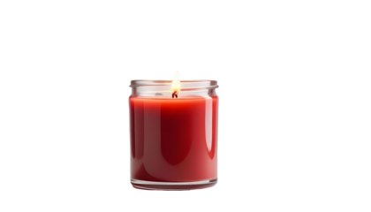A red candle burns brightly in a glass jar, with a cozy winter Christmas backdrop