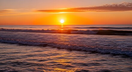 Fototapeta premium A vibrant sunrise paints the ocean with hues of orange and gold, showcasing a tranquil morning on the shoreline.