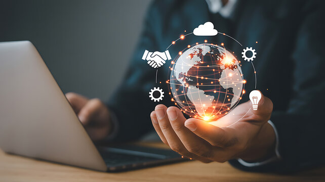 Businessman holding glowing digital globe with business icons and laptop global technology - Powered by Adobe