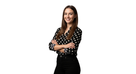 Young woman poses confidently with arms crossed in a studio setting, wearing a stylish polka dot blouse and black pants