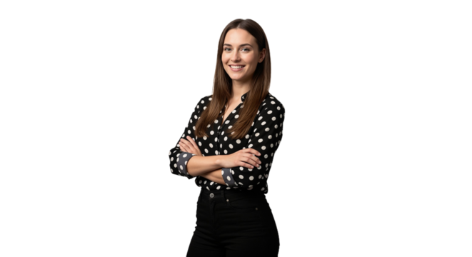 Young woman poses confidently with arms crossed in a studio setting, wearing a stylish polka dot blouse and black pants