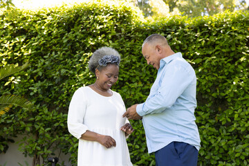 African American senior couple enjoying joyful moment together in garden
