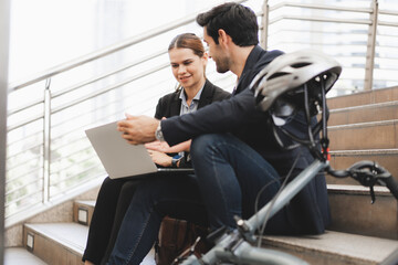Commuting to work with bicycle. Businessman businesswoman cycling to office in downtown district....