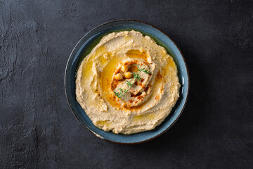A traditional dish or appetizer hummus or baba ghanoush on black background	