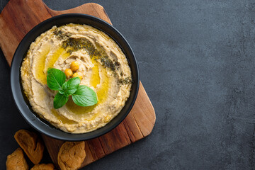 A traditional dish or appetizer hummus or baba ghanoush on black background	