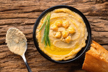 A traditional dish or appetizer hummus or baba ghanoush on wooden background	
