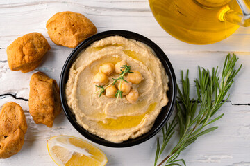  A traditional dish or appetizer hummus or baba ghanoush on white wooden background