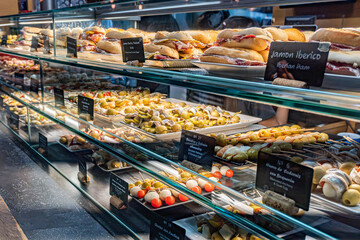 Freshly prepared pintxos featuring chicken skewers with curry-mango sauce and croquettes topped...