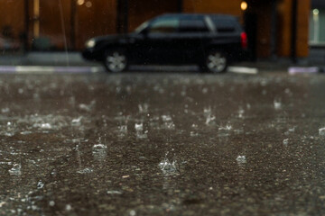 rain in the city, the flow of water along the city street during a downpour, bubbles, drops and...