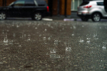rain in the city, the flow of water along the city street during a downpour, bubbles, drops and...