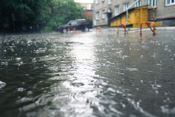 rain in the city, the flow of water along the city street during a downpour, bubbles, drops and...