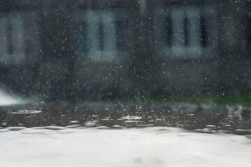rain in the city, the flow of water along the city street during a downpour, bubbles, drops and...