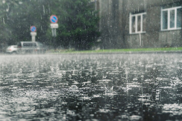 rain in the city, the flow of water along the city street during a downpour, bubbles, drops and...