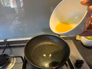 Pouring Beaten Egg into Hot Frying Pan with Oil
