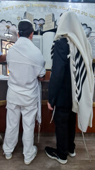 A Bar Mitzvah boy and his father standing by the Torah ark