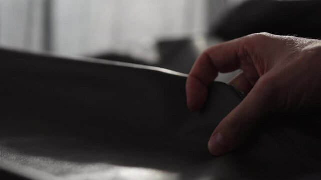 Slow motion shot man touching fine leather closeup