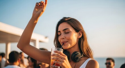 A woman enjoys a cocktail on the beach. She's got headphones on, maybe ready to party the night away.


